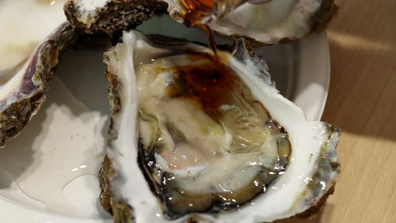生牡蠣にポン酢をかける様子