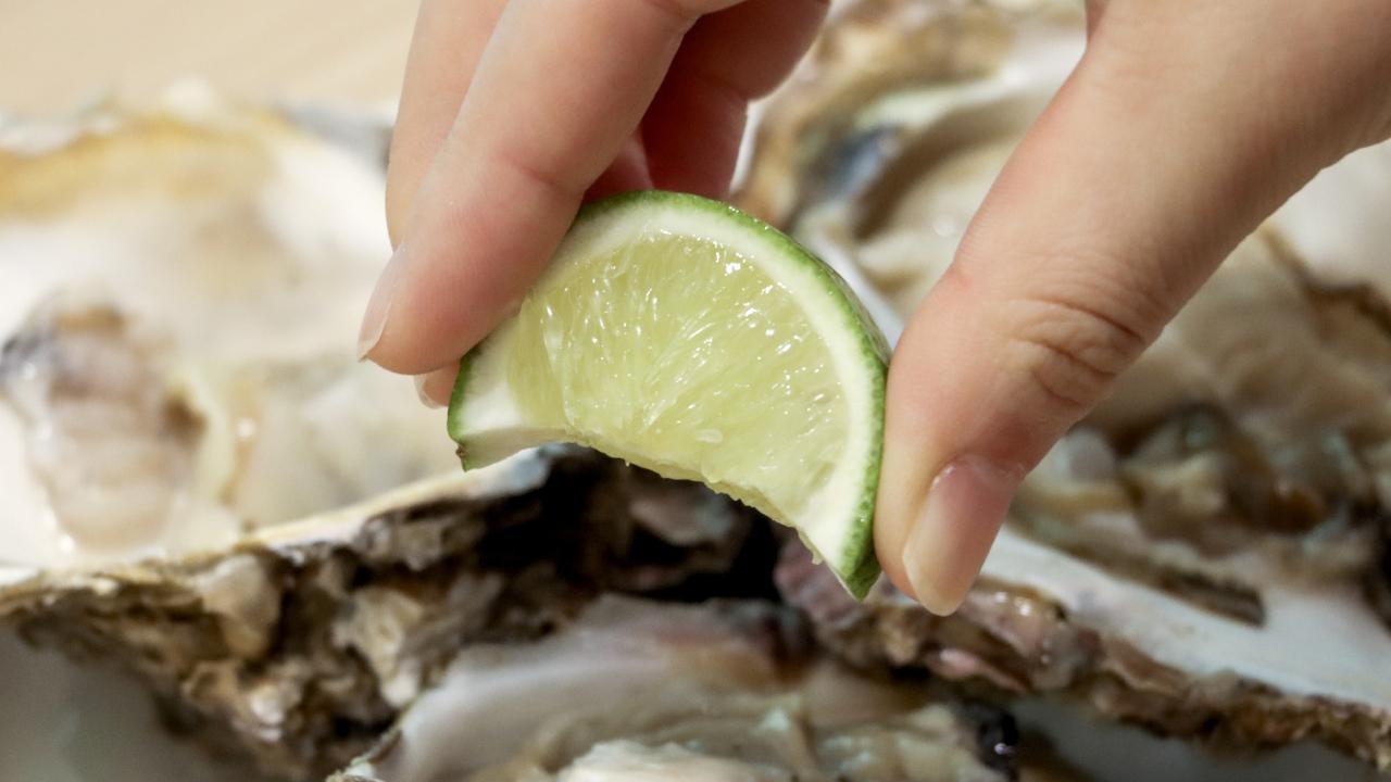 生牡蠣にライムを絞る様子